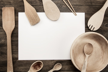 white sheet of paper with utensils on the old wooden background. Mock up
