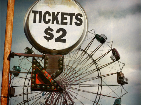 aged and worn vintage photo of ticket sign at carnival with ferris wheel