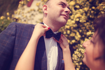 Bride helping the groom with the bowtie