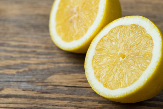 Two fresh and juicy lemons on wooden table