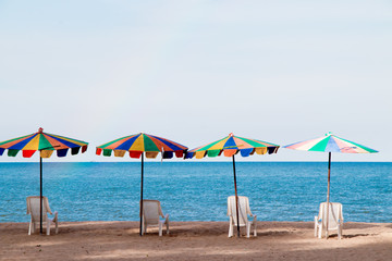 Beach chairs with colorful umbrella at the beach with blue-sky background on summer.