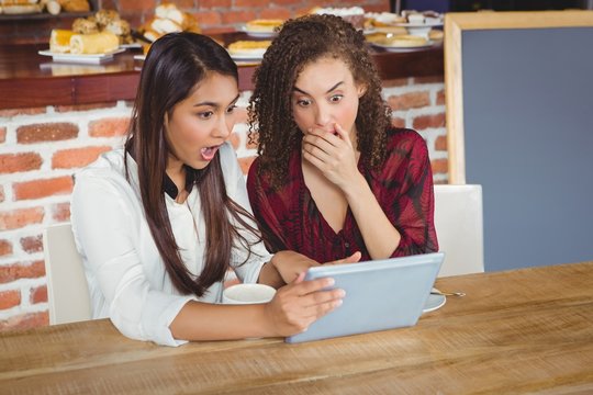 Pretty female friends shocked by using tablet pc