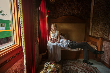 Obraz na płótnie Canvas Just Married Bride and Groom Sitting in Luxury Train. Wedding and Honeymoon Travel
