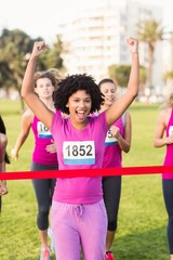 Obraz premium Cheering young woman winning breast cancer marathon