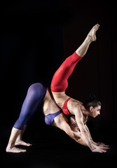 Fototapeta na wymiar Two women practicing gymnastic yoga, studio shot