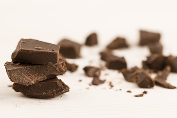 Broken chocolate bar on wooden background, close-up