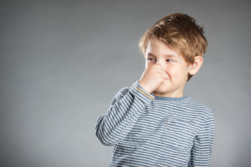 Portrait, Junge, grauer Hintergrund, Nase zuhalten