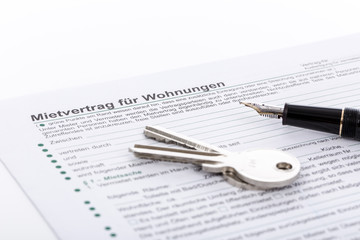 Mietvertrag, Wohnungsschl&uuml;ssel und Federhalter zum Unterschreiben
