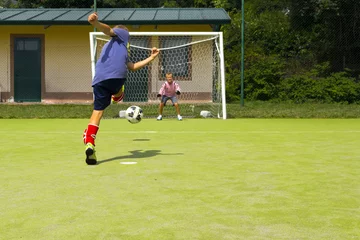 Keuken achterwand Voetbal Voetbal voetbalwedstrijd voor kinderen. Kind schopt de bal  © caifas