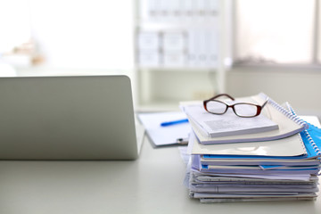 Stack of papers and glasses lying on table desaturated