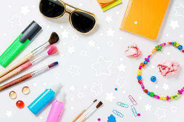 Photo of workplace with lots of stationery objects and glasses.