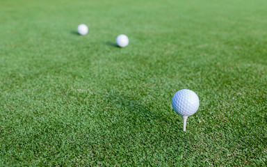 Golf ball and tee on green grass during training at golf club.
