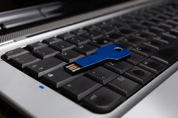 Blue usb key on laptop keyboard