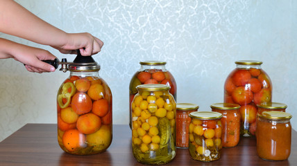 housewife closes  banks of homemade preserves