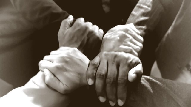 Four businessmen join hands close shot 