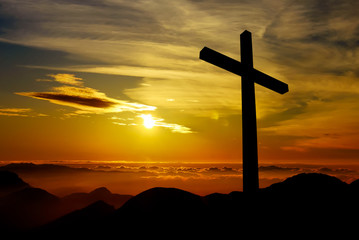 Christian cross on sunset background