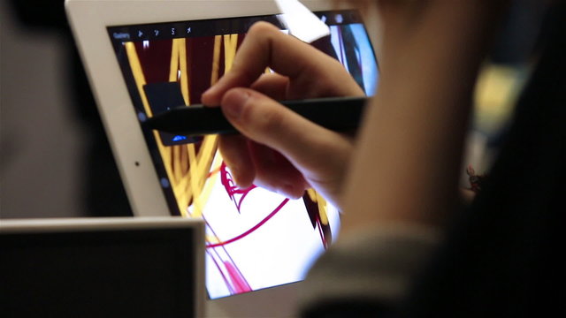 Girl draws a brush on the tablet, using  technology of digital mobile painting