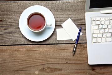 Obraz na płótnie Canvas on vintage table tea,laptop and business cards