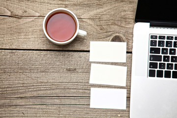 on vintage table tea,laptop and business cards