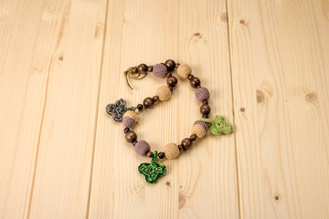 Crochet baby handmade beads with acorns and leaves on a wooden t