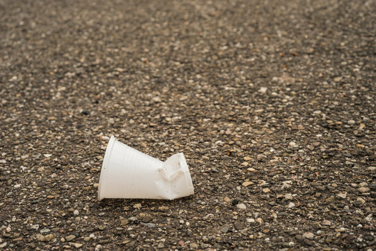 Symbol Wegwerfgesellschaft – gebrauchter Plastikbecher liegt auf der Straße