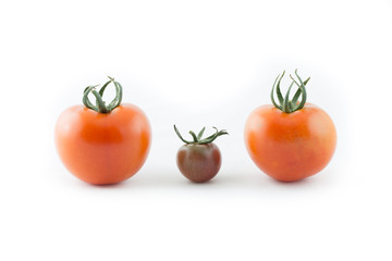 Tomatoes isolated on white - Small tomato in between two large regular tomatoes.