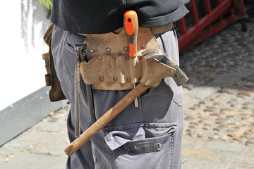 Worker with tool belt working on the street