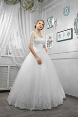 Young beautiful bride, woman in long white wedding dress on whit