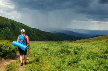 Young woman stands on hill in a thunderstorm