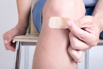 close up of adhesive medical patch on male knee