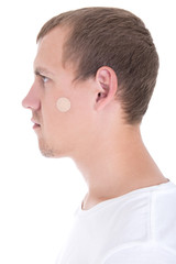 Obraz premium young man with plaster on his face isolated on white