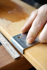 Schreiner oder Handwerker beim Anzeichnen von Holz für Baustelle und Renovierung