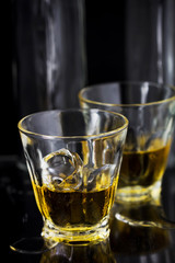 Two glasses of whiskey with ice cubes