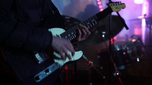 Guitarist perform for fans at a rock concert.