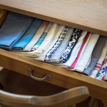 Tea towels arranged in a drawer of dining table