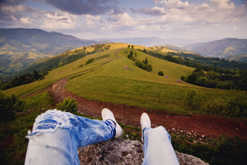 Fototapeta premium Tourist hiker sitting on the rock in mountain