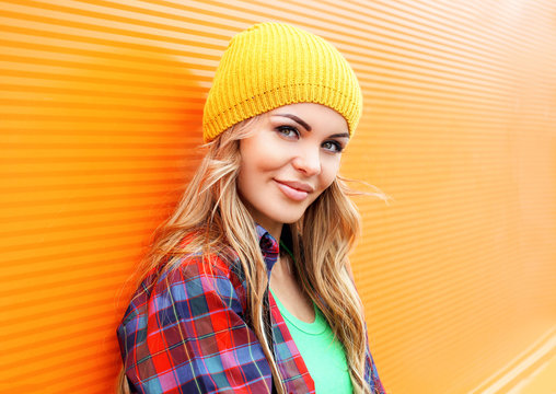 Portrait of pretty blonde woman in colorful clothes outdoors