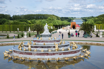 Visitors in garden Palace Versailles with statue and pond at Paris, France