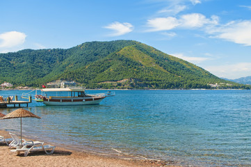 tourist boat moored at small pier at beach