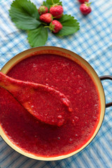 Homemade strawberry jam (marmelade) cooking. Large pot with hot jam and fresh strawberries