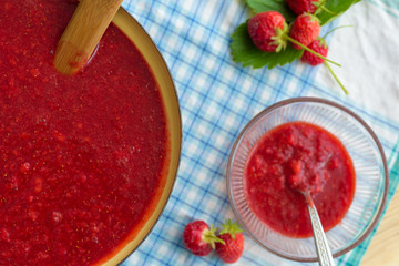 Homemade strawberry jam (marmelade) cooking. Large pot with hot jam and fresh strawberries