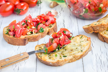 Bruschetta with tomatoes, herbs and oil on toasted garlic cheese bread