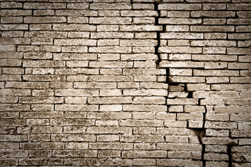 Deep crack in old brick wall - sepia toned image - obrazy, fototapety, plakaty