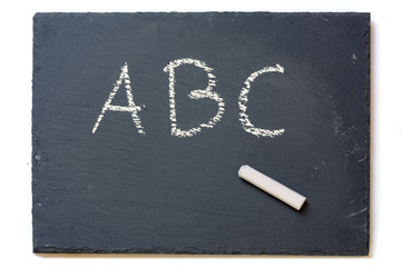 chalkboard with chalk and the letters A, B, C, isolated on white
