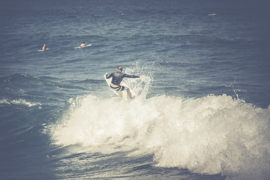 Vintage photo professional surfer rides a giant wave.