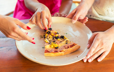 Anonymous female friends sharing a pizza