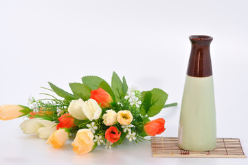 Colorful flower with vase on bamboo mat.