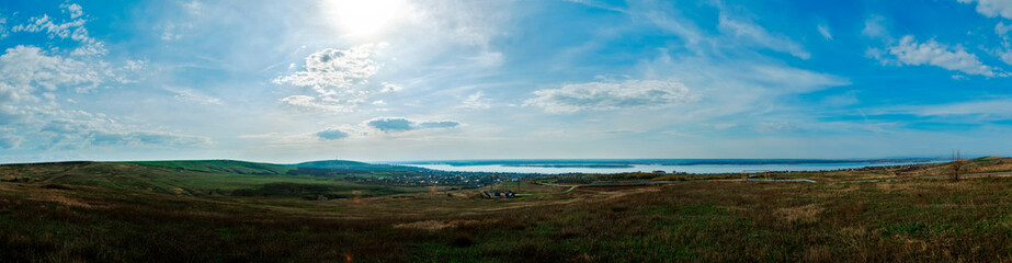 panorama with sun on town near river