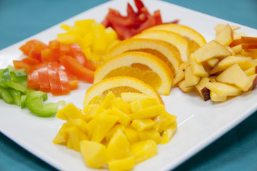 Vegetable and fruit plate with mangoes, oranges, and other fruits and vegetables 