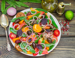 Fototapeta na wymiar Salad of yellow and red tomatoes with green peas
